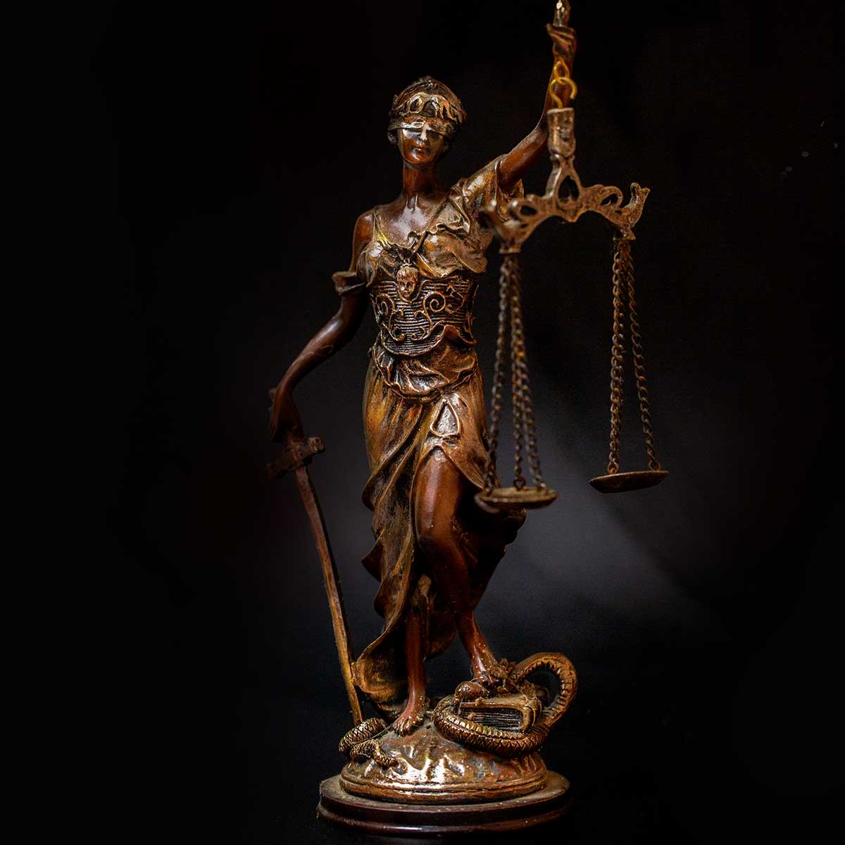 A statuette of a blindfolded Lady Justice, holding scales and a sword.