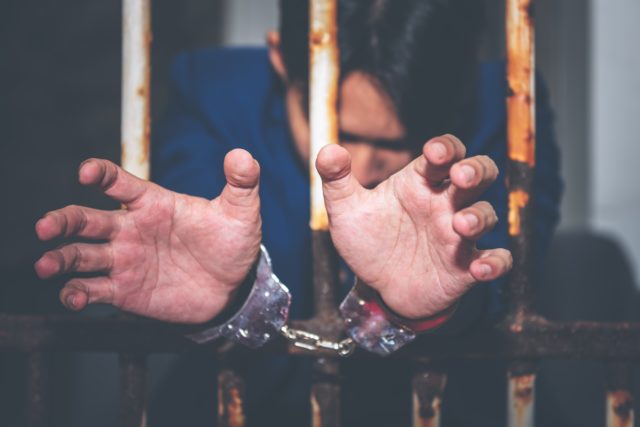 Prisoner with handcuffs in jail